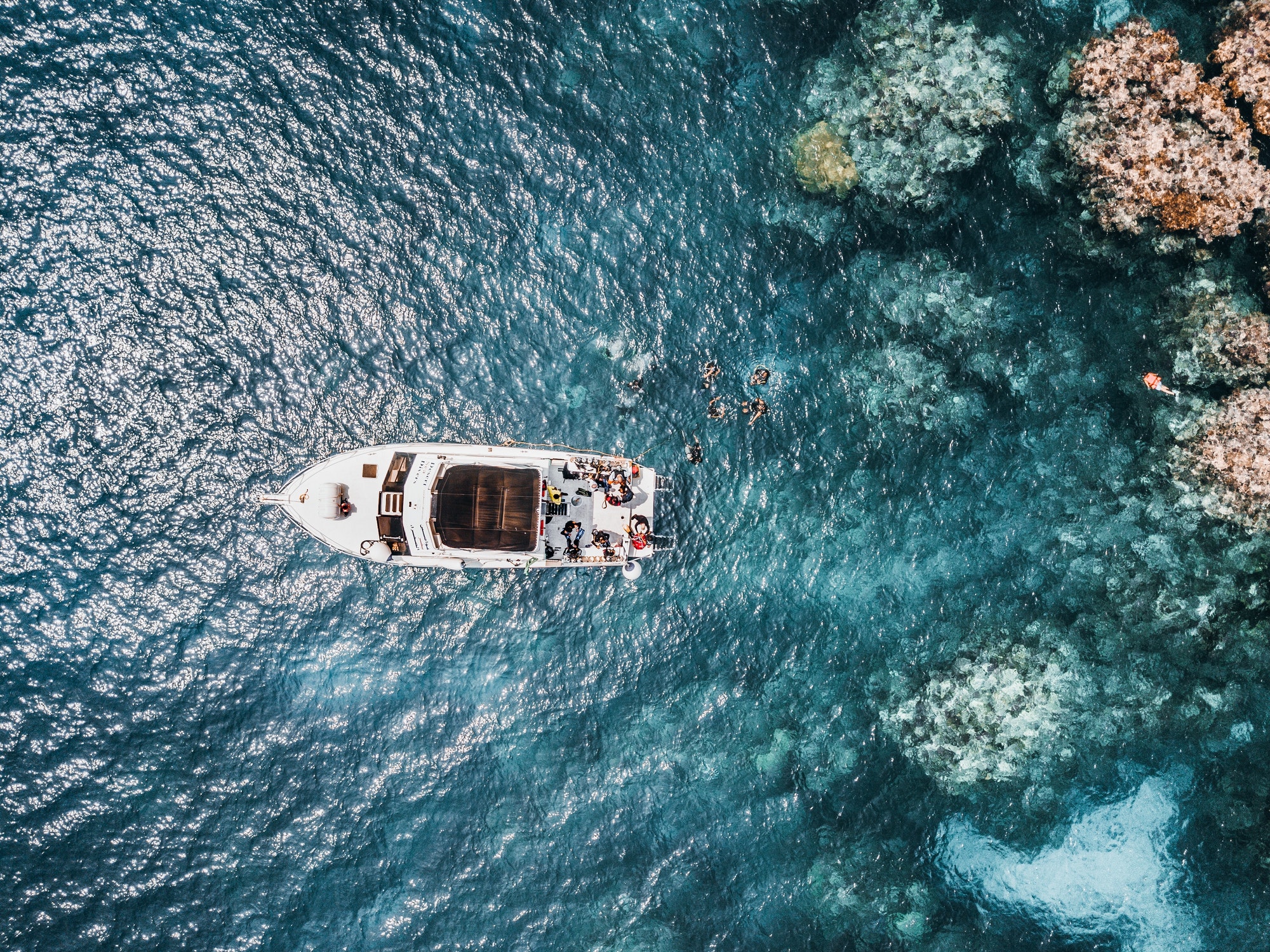 Boat in the Red Sea near the reefs while people scuba diving